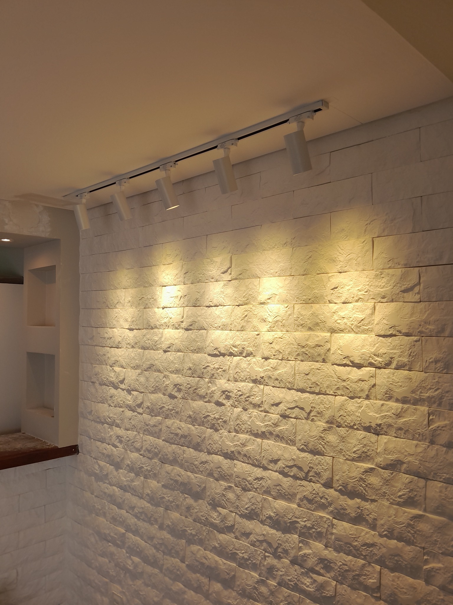 Parede de pedra com iluminação em trilho